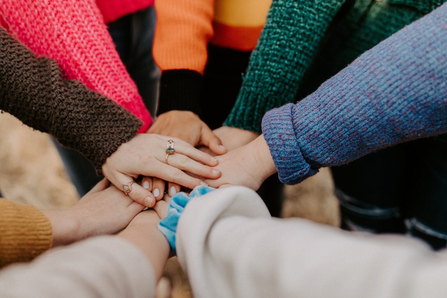 Eight hands, in a circle, on top of each other